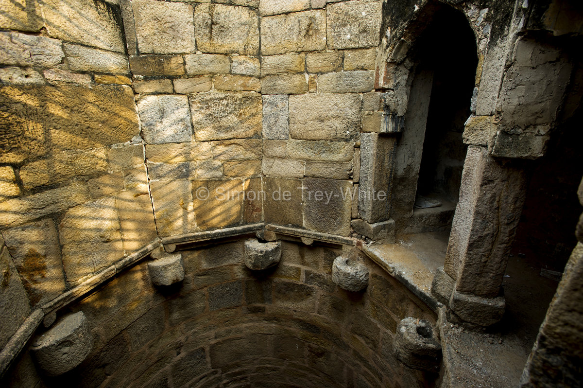 The well shaft of Rajon Ki Baoli in Mehrauli complete with stone rope-guides and grooved pillars above to take the ropes