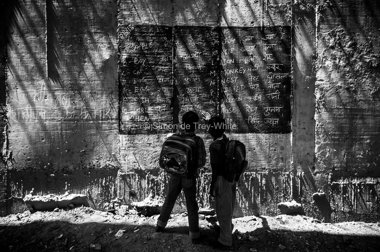 Boys read from a blackboard painted onto the walls of a metro bridge at a makeshift school in New Delhi, 8th April 2013